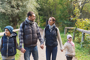 Image showing happy family with backpacks hiking in woods