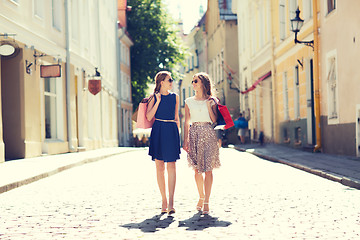 Image showing happy women with shopping bags walking in city