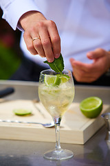 Image showing Bartender in nature preparing alcoholic drink mojito.