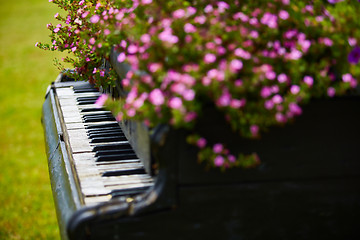 Image showing Old wooden piano decorated with flowers