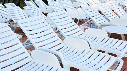 Image showing number of empty sunbeds at the pool early in the morning