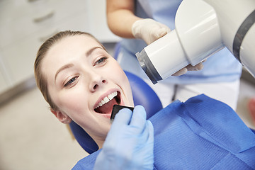 Image showing female patient face with x-ray machine and shield