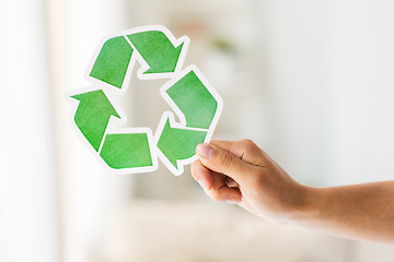 Image showing close up of hand holding green recycle symbol