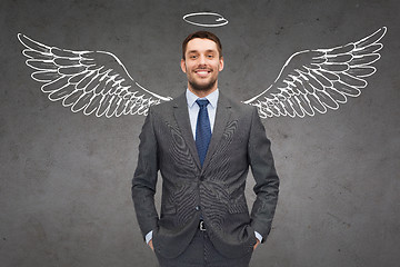 Image showing smiling businessman with angel wings and nimbus