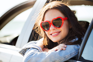 Image showing happy teenage girl or young woman in car