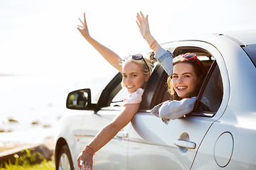 Image showing happy teenage girls or women in car at seaside