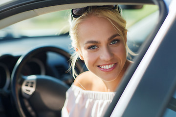 Image showing happy teenage girl or young woman in car