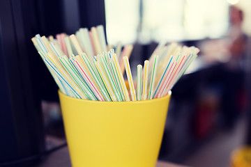 Image showing close up of cocktail straws in glass at restaurant