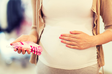 Image showing pregnant woman with baby socks at clothing store
