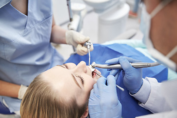 Image showing close up of dentist treating female patient teeth