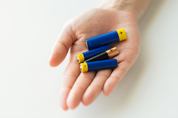 Image showing close up of hands holding alkaline batteries heap