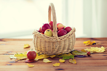 Image showing close up of basket with apples on wooden table