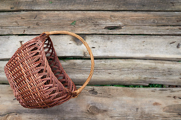 Image showing Wicker basket on weathered wooden background