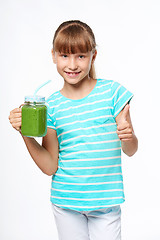 Image showing Girl holding jar tumbler mug with green smoothie drink