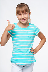 Image showing Smiling elementary school age girl showing thumb up
