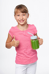 Image showing Girl holding jar tumbler mug with green smoothie drink