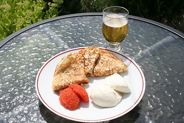 Image showing Crepes, caviar, creme fraiche and a glass of cold beer