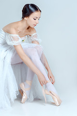 Image showing Professional ballerina putting on her ballet shoes