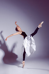 Image showing Ballerina in black outfit posing on toes, studio background.