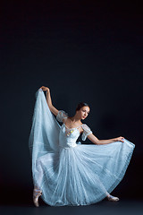 Image showing Portrait of the classical ballerina in white dress on black background