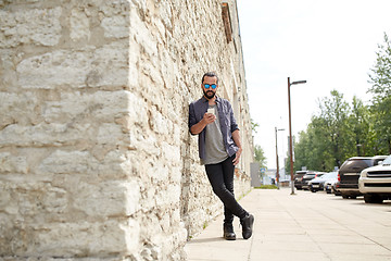 Image showing man texting message with smartphone on city street