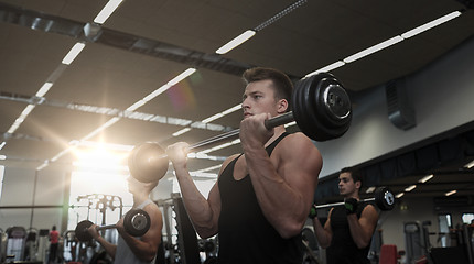 Image showing group of men flexing muscles with barbell in gym