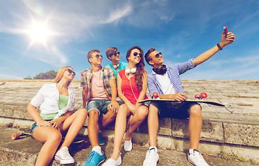 Image showing group of smiling friends with smartphone outdoors