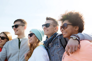 Image showing happy teenage friends in shades hugging outdoors