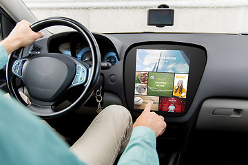 Image showing man driving car with news on board computer