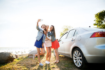 Image showing happy women taking selfie near car at seaside