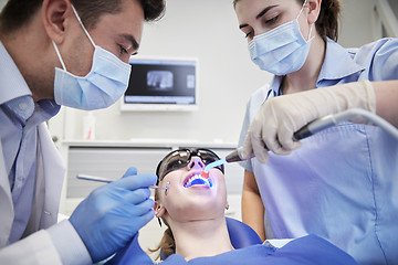 Image showing dentists treating woman patient teeth at clinic