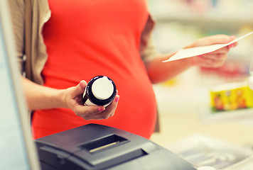 Image showing pregnant woman buying medication at pharmacy