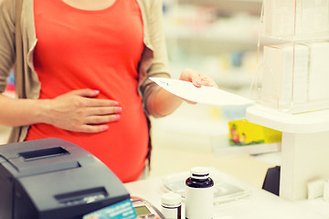 Image showing pregnant woman buying medication at pharmacy