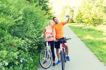 Image showing couple with bicycle and smartphone taking selfie
