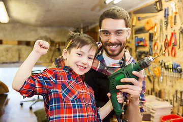 Image showing father and son with drill working at workshop