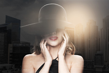 Image showing beautiful woman in black hat over dark background