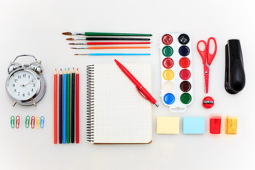 Image showing School set with notebooks, pencils, brush, scissors and apple on white background