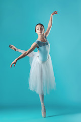 Image showing Ballerina in white dress posing on toes, studio background.