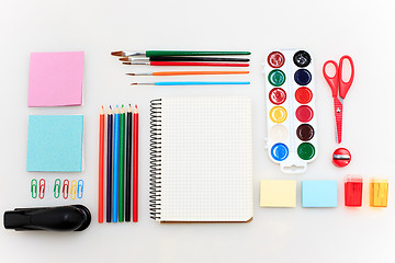 Image showing School set with notebooks, pencils, brush, scissors and apple on white background
