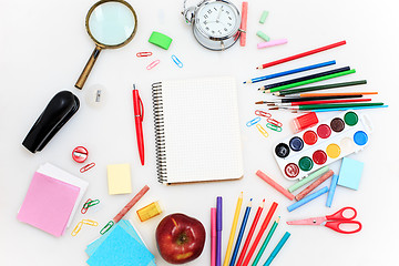 Image showing School set with notebooks, pencils, brush, scissors and apple on white background