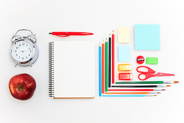 Image showing School set with notebooks, pencils, brush, scissors and apple on white background