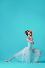 Image showing Ballerina in white dress posing on toes, studio background.