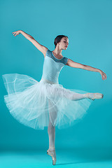 Image showing Ballerina in white dress posing on toes, studio background.