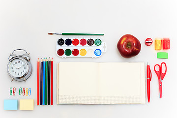 Image showing School set with notebooks, pencils, brush, scissors and apple on white background