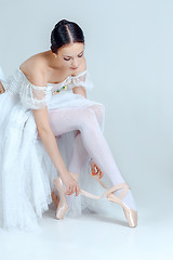 Image showing Professional ballerina putting on her ballet shoes