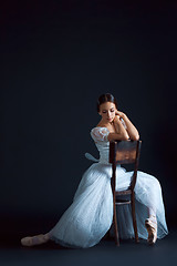 Image showing Portrait of the classical ballerina in white dress on black background