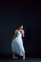 Image showing Portrait of the classical ballerina in white dress on black background