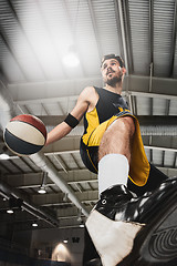 Image showing The portrait of a basketball player with ball against gray gym background