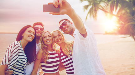 Image showing happy friends taking selfie by smartphone on beach