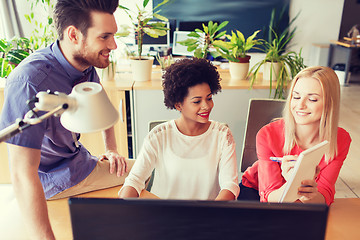 Image showing happy creative team with computer in office